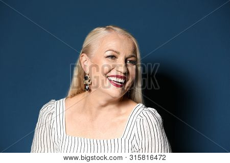 Portrait Of Beautiful Mature Woman On Blue Background