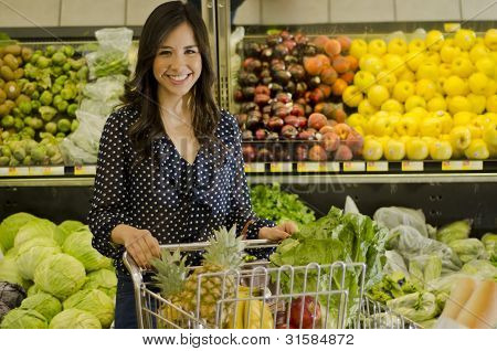Mujer feliz en la tienda de comestibles