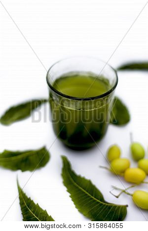 Detox Or Detoxifying Drink Of Neem Fruit In A Glass Isolated On White Along With Some Neem Fruit Or