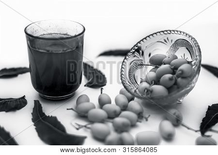 Detox Or Detoxifying Drink Of Neem Fruit In A Glass Isolated On White Along With Some Neem Fruit Or