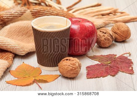 Cup Of Coffee, Walnut, Apple And Dry Leaves In An Autumn Still Llife.