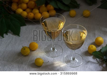 Cherry Plum Liqueur In Small Glasses And Cherry Plum On A Wooden Background. Rustic Style.
