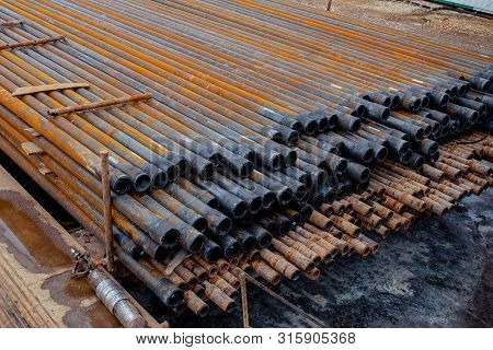 Drill Pipe Of Oil Drilling Platforms. Stack Of Oil Well Casing Bundles At The Pin End Of Casing. Dow