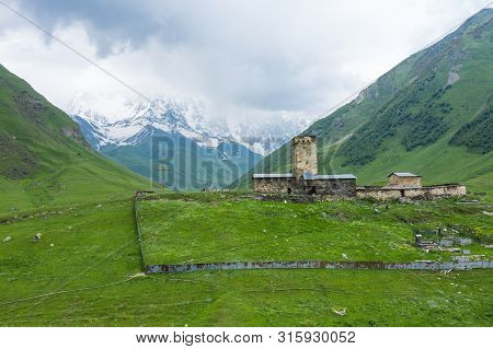 View Of The Ushguli Village At The Foot Of Mt. Shkhara. Lamaria Monastery, Rock Tower Towers And Old