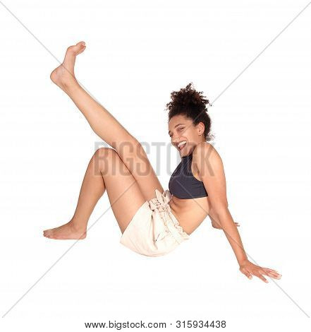 A Lovely Multi-racial Woman In A Black Top And Beige Shorts Sitting
In The Studio On The Floor With 