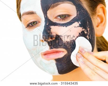 Woman With Clay Carbo Black Mask On One Half Face And White Mud On Second Half. Girl Removing Cosmet
