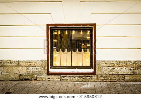 Old Vintage Window Of Below Ground Floor With Cosy Electric Lighting.