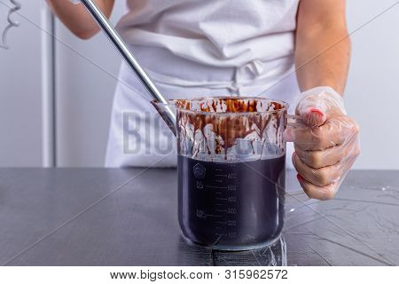The Pastry Chef In The Kitchen Glazes Pastries. Cook Makes Chocolate Frosting With A Mixer. Master C
