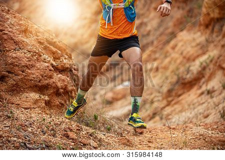 A Man Runner Of Trail . And Athlete's Feet Wearing Sports Shoes For Trail Running In The Forest