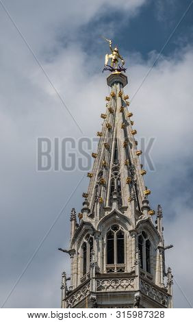 Brussels, Belgium - June 22, 2019: Closeup Of Gray Stone Spire Of City Hall On Grand Place Against B