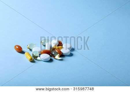 A Lot Of Bright Colored Medicine Pills On A Blue Background. Cropped Shot, Vertical, Side View, Clos