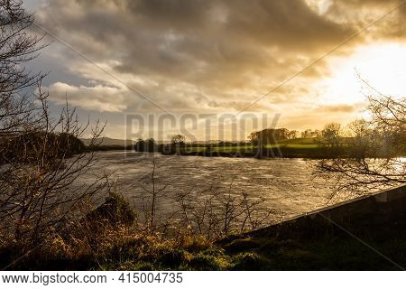 Sun Setting Over The River Dee At Glenlochar Bridge, On A Winter Afternoon, Dumfries And Galloway, S