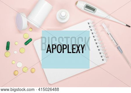 Notebook Page With Text Apoplexy On A Table With Pills And Syringe. Medical Concept.