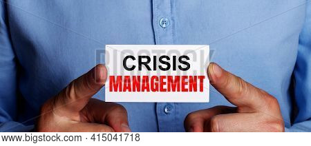 The Words Crisis Management Is Written On A White Business Card In A Man's Hands. Business Concept
