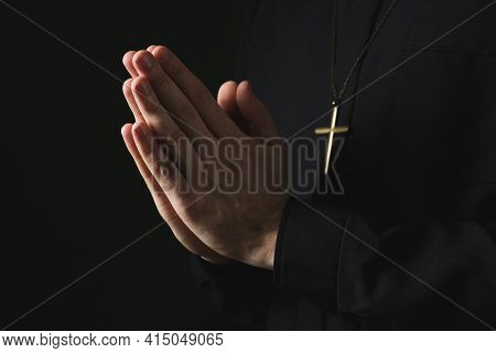 Priest In Cassock Praying On Dark Background, Closeup