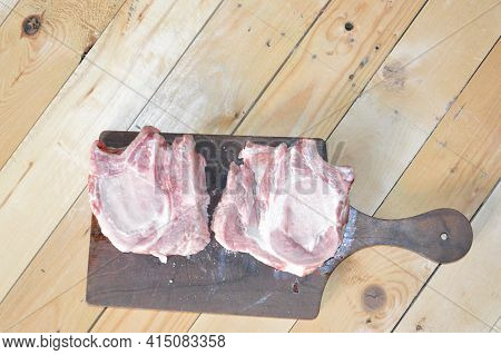 Salted And Peppery Steak Lies On A Wooden Stand