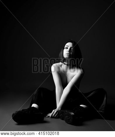 Black And White Portrait Of Young Sexy Brunette Woman In Leather Pants And Brutal Choes Sitting On F