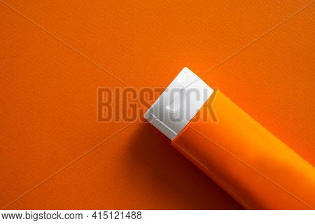Sun Block Or Sun Screen Tube On Orange Paper.cream Or Lotion Cosmetics For Woman On A Day In The Str