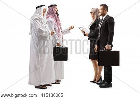 Full length profile shot of a businessman and businesswoman talking to two arab men isolated on white background