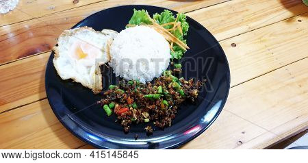 Thai Food Stir-fried Chicken Spicy And Basil Served With Rice ,fried Egg And Tomato Cucumber Carved 