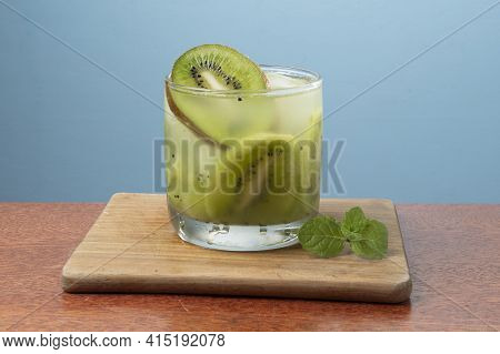 Alcoholic Drink Caipirinha Based On Kiwi And Aguardente Distilled Cocktail Drink And Fruits On Blue 