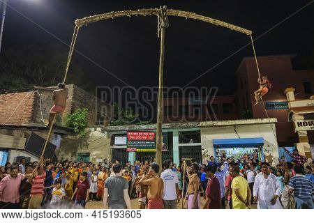 Howrah, West Bengal,india - 15th April 2019: Two Hindu Devotees Are Hanging From Pole In Air, At Nig