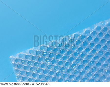 Bubble Wrap Packing Or Air Cushion Film On Blue Background. Closeup, Copy Space.