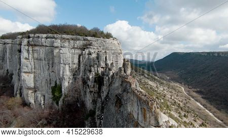 Top View Of Rocky Cliff On Background Horizon Of Mountains. Shot. Beautiful Landscape With Majestic 