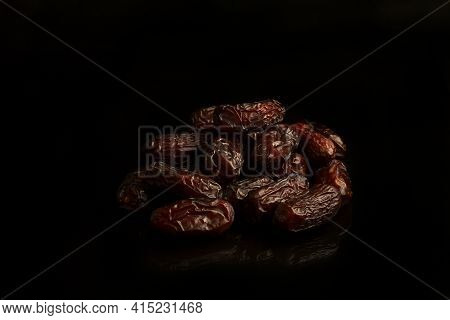 Dates On A Black Background. Dried Fruits. Dried Dates Lie Next To Each Other