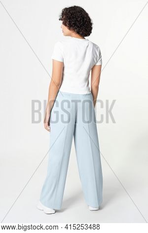 Woman in white tee and blue loose pants minimal fashion rear view