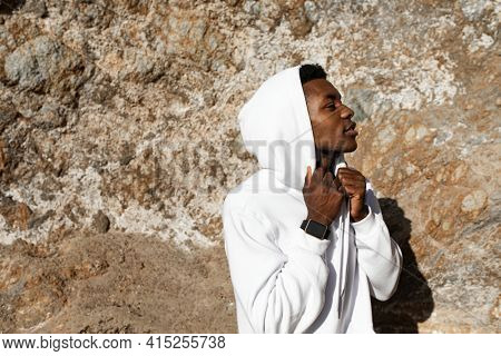 African American man in white hoodie posing outdoor photoshoot