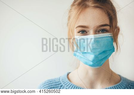 Close Up Photo Of A Caucasian Woman With Ginger Hair And Freckles Smiling At Camera Wearing A Medica
