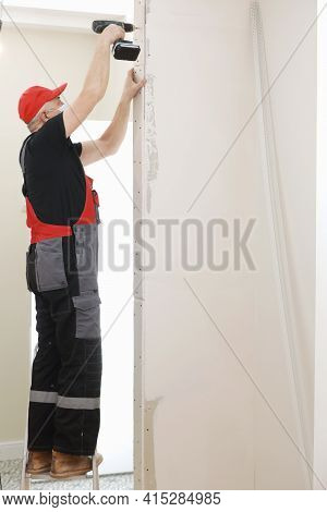 The Installer Worker In Safe Medical Mask And Overalls Fixes A Detail Of The Stiffener Element With 