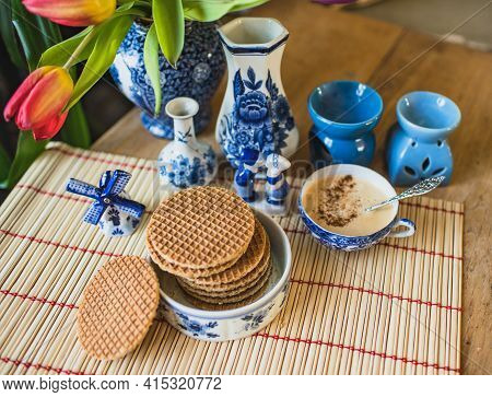 Typical Dutch Blue Crockery On The Table With Traditional Dutch Cookies Stroopwafels And Fresh Red T