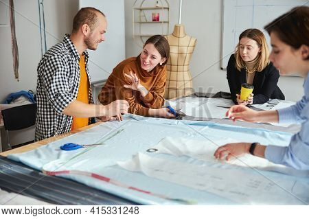Female Tailor Explaining Something To Male Near Her