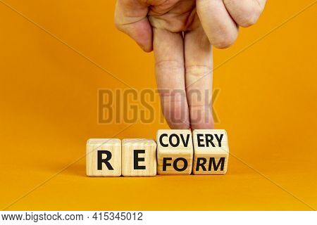 Recovery And Reform Symbol. Businessman Turns Cubes And Changes The Word 'recovery' To 'reform'. Bea