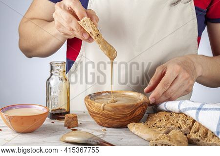 A Caucasian Woman Wearing Apron Is Dipping Turkish Pide (flat Bread) With Sesame And Poppy Seeds Int
