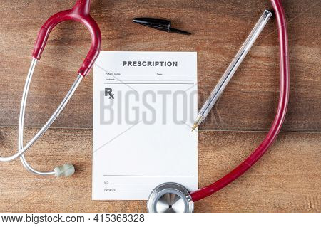 Close Up Isolated Flat Lay Image Of A Physician's Desk Where There Is A Pen, Sthetoscope And A Blank