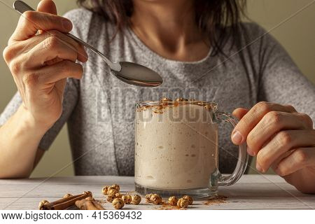 Woman Eating A Viscose Malted Barley, Wheat Beverage Served In A Cup With Roasted Chickpeas (leblebi