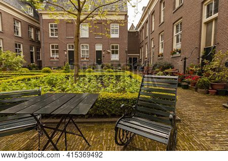 Close Up Image Of Rustic Metal Chair And Table At Acourtyard Garden In A Senior Housing Community. I