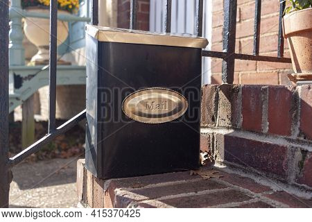 Close Up Isolated Image Of A Small Size Vertical Mail Box That Is Attached To The Railings Of The Br