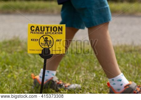 A Yellow Yard Sign Warning Kids And Pets Of The Recent Pesticide Spraying And Advices Them To Stay A