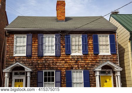 Annapolis, Md 08/21/2020: A Vintage Semidetached House With Wooden Tile Exterior And Dark Blue Windo