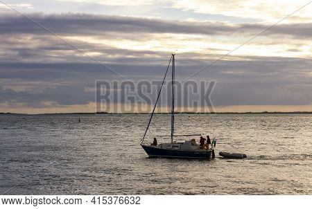 Anglesey, Wales, Uk 08/26/2012: A Small Boat With Three Passengers In It Is Sailing Off The Coast Of