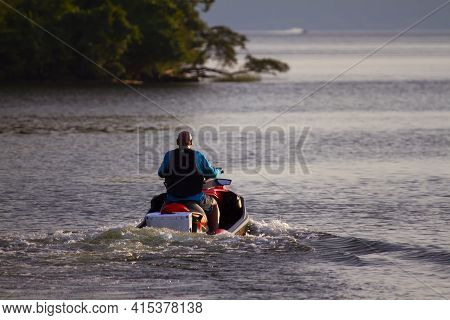 A Man With A Shaved Head Wearing Life Vest Is Riding A Personal Water Craft In Mallows Bay Of Potoma