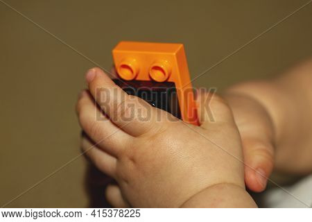 Close Up Image Of An Infant Baby's Hands As He Or She Is Trying To Put Together Blocks. Image Is Use
