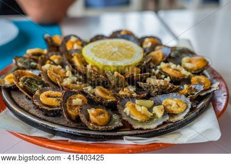 Tasty Seafood - Grilled Limpets Served With Lemon. Lapas Grelhadas. Azores Traditional Dish And A Ty