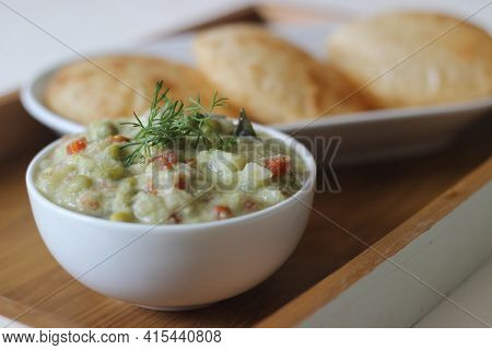 Mixed Vegetable Curry In A Coconut Cashew Gravy Served With Deep Fried Indian Flat Bread