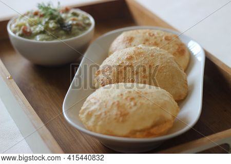 Deep Fried Indian Flat Bread Served With Mixed Vegetable Curry In A Coconut Cashew Gravy
