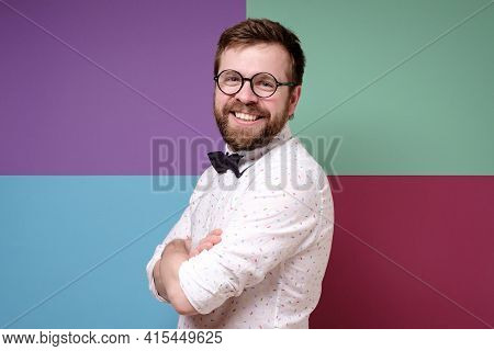 Attractive, Benevolent Man In Glasses, In A Shirt And A Bow Tie, Crossed Arms And Looked At The Came